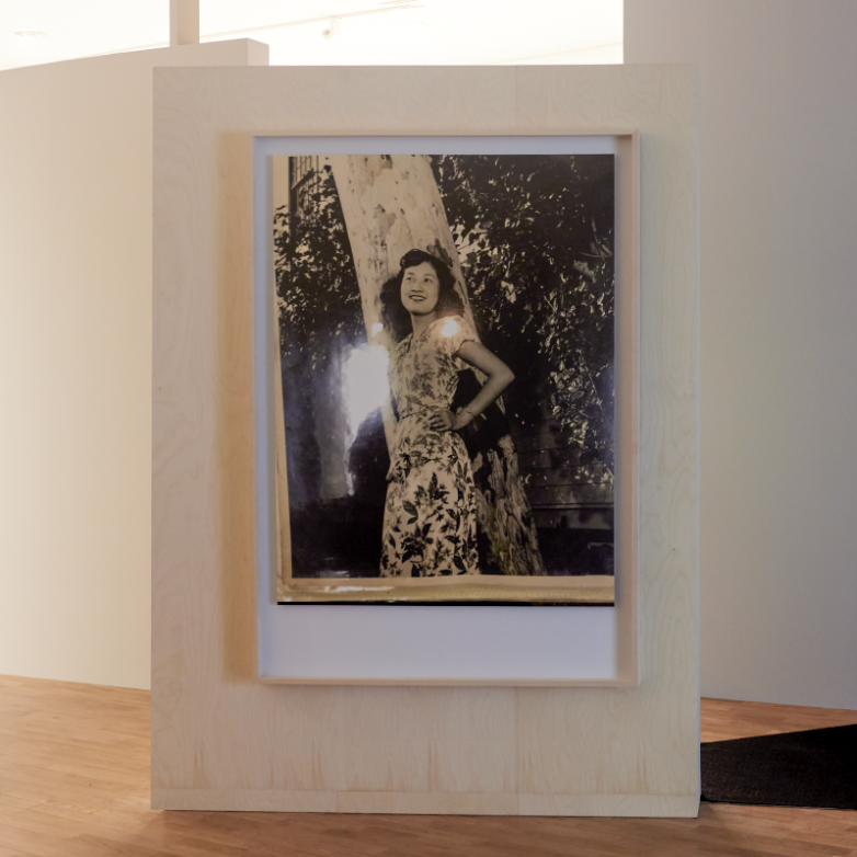 Unidentified woman standing next to a tree